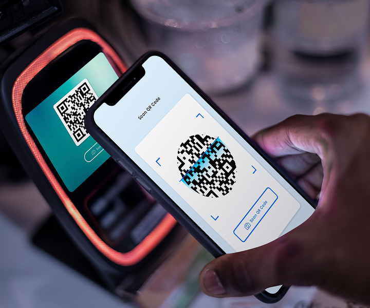 Scanning QR code with smartphone at terminal.