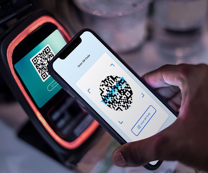 Scanning QR code with smartphone at terminal.