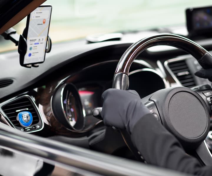 Driver using GPS navigation in a car.
